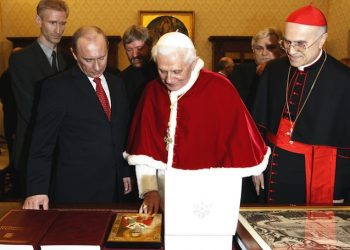Pope Benedict XVI looks at a gift presented him by Russia's President Vladimir Putin at the Vatican Tuesday, March 13, 2007. It was the highest-level Kremlin-Vatican talks in more than three years, a meeting expected to focus on ways of easing tensions between Catholics and Orthodox Christians and finding common ground on moral issues. The meeting - the first between Benedict and Putin - is part of a visit that takes the Russian leader to Italy and Greece this week. At right is Cardinal Tarcisio Bertone, Vatican Secretary of State. (AP Photo/Andrew Medichini, Pool)