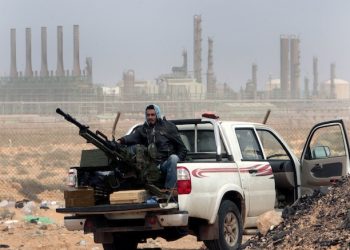 FILE - In this March 5, 2011 file photo, an anti-government rebel sits with an anti-aircraft weapon in front an oil refinery in Ras Lanouf, eastern Libya. The United States France, Germany, Italy, Spain and Britain have called upon forces loyal to a Libyan general to withdraw from three eastern oil terminals seized earlier this week, in a statement Monday, Sept. 13, 2016. The oil-rich North African country slid into chaos after the 2011 uprising that toppled and killed Moammar Gadhafi. (AP Photo/Hussein Malla, File)