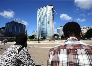 Due migranti questa mattina in piazza Duca d'Aosta, sullo sfondo il Pirellone, sede del consigliano regionale della Lombardia, Milano, 10 agosto 2016.
ANSA / MATTEO BAZZI