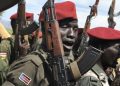 In this photo taken Thursday, April 14, 2016, government soldiers follow orders to raise their guns during a military parade in Juba, South Sudan. When South Sudan's president signed a peace deal a year ago to end the country's civil war he added 16 reservations to the agreement, which have now become a map of how it has unraveled. (AP Photo/Justin Lynch)
