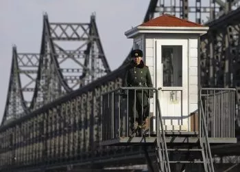 epa03651696 A Chinese soldier stand guard at a guard post beside the Sino-Korean Friendship Bridge connecting Sinuiju, North Korea, along the Yalu River in the Chinese city of Dandong, Liaoning Province, China, 06 April 2013. North Korean leader Kim Jong-un has ordered the country's military to increase artillery production, a televised report out of Pyongyang showed 06 April.  EPA/HOW HWEE YOUNG