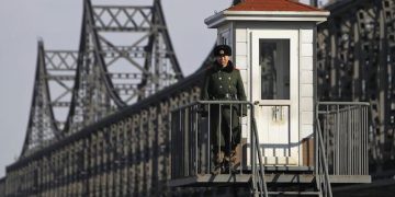 epa03651696 A Chinese soldier stand guard at a guard post beside the Sino-Korean Friendship Bridge connecting Sinuiju, North Korea, along the Yalu River in the Chinese city of Dandong, Liaoning Province, China, 06 April 2013. North Korean leader Kim Jong-un has ordered the country's military to increase artillery production, a televised report out of Pyongyang showed 06 April.  EPA/HOW HWEE YOUNG