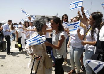 epa05433362 Israelis wave national flags as they welcome newly-arrived Jewish immigrants from France at Ben Gurion Airport, in Lod, near Tel Aviv, Israel, 20 July 2016. A flight carrying 200 French Jews immigrating to Israel arrived on 20 July. Jewish immigration to Israel has significant increased since 2013 from France, which has the largest Jewish community in Europe with almost half a million.  EPA/ABIR SULTAN