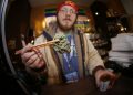 FILE--In this Friday, Dec. 9, 2014, file photograph, Matt Hart holds up a bud of Lemon Skunk, the most potent strain of marijuana available at the 3D Dispensary in Denver. A bill making its way through the Colorado legislature may allow recreational pot growers to instantly re-classify their product as medicinal grow if there is a change in federal law or enforcement. (AP Photo/David Zalubowski, file)
