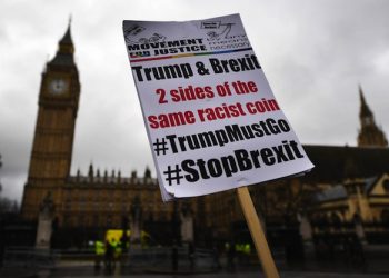 epa05764898 A placard reading 'Trump and Brexit two sides of the same racist coin' is seen during a protest against parliament's vote to invoke Article 50 outside parliament in London, Britain, 01 February 2017. Parliament is holding its final day in a two-day long debate on the bill to trigger Article 50 and Britains exit from the EU. MP's will vote to trigger Article 50 on 01 February.  EPA/ANDY RAIN