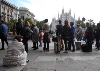 Persone in coda per un Taxi in piazza del Duomo a Milano. Autobus e metropolitane sono ferme a causa di uno sciopero  indetto dai  lavoratori di Atm, l'azienda del trasporto pubblico milanese, che si asterranno dal lavoro per quattro ore. Milano  5 aprile 2017.
ANSA / MATTEO BAZZI