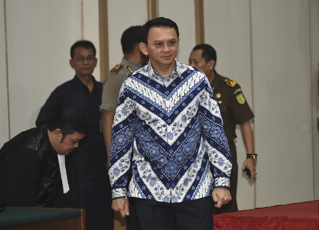 Jakarta Governor Basuki "Ahok" Tjahaja Purnama, center, enters the court room as he attends his sentencing hearing in Jakarta, Indonesia, Tuesday, May 9, 2017. The minority Christian governor is currently on trial on accusation of blasphemy following his remark about a passage in the Quran that could be interpreted as prohibiting Muslims from accepting non-Muslims as leaders. (Bay Ismoyo/Pool Photo via AP)