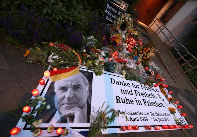 epa06034307 A banner reading 'Thank you for peace and freedom. Rest in peace.' lays next to lit candles and flowers in front of the house of former German Chancellor Helmut Kohl in Oggersheim, Ludwigshafen, Germany, 17 June 2017. Helmut Kohl has died at the age of 87 in his home in Ludwigshafen on 16 June 2017.  EPA/MICHAEL DEINES