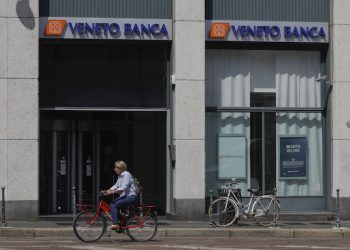 A woman bikes pasta Veneto Banca branch in Milan, Italy, Monday, June 26, 2017. Premier Paolo Gentiloni defended the swift action by the government as vital for ensuring Italy's slow economic recovery isn't derailed by a "disorderly" failure of Veneto Banca and Banca Popolare di Vicenza. The two banks are based in the northeast Veneto region, one of Italy's most economically productive. They serve many of the small and medium-sized businesses that are the backbone of the nation's economy.(AP Photo/Luca Bruno)