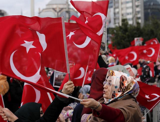 epa04533633 Supporters of the Hizmet movement of US-based Islamic cleric Fethullah Gulen shout slogans as they wave Turkish flags outside a courthouse in Istanbul, Turkey 18 December 2014. A Turkish prosecutor on 16 December formally dropped all charges against government officials stemming from a high-profile corruption investigation that exploded into the headlines last December. The corruption investigation forced four ministers to resign and threatened the stability of the government. Then prime minister Erdogan blamed the investigation on a so-called parallel state, which he claims is run by US-based Islamic cleric Fethullah Gulen.  EPA/TOLGA BOZOGLU