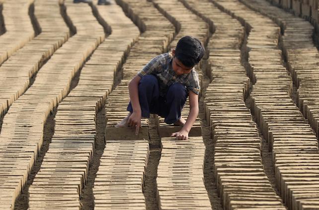 epa05184244 A boy works at a brick kiln on the outskirts of Lahore, Pakistan, 27 February 2016. The provincial government of Punjab enacted a new ordinance titled 'Punjab Prohibition of Child Labor at Brick Kilns Ordinance 2016' in January 2016, prohibiting the employment of children under the age of 14 years at brick kilns. The ordinance prohibits owners from employing, engaging or permitting a child to work at a brick kiln.  EPA/RAHAT DAR