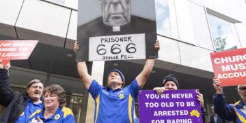 Folla con manifesti contro George Pell davanti al tribunale durante il processo per pedofilia
