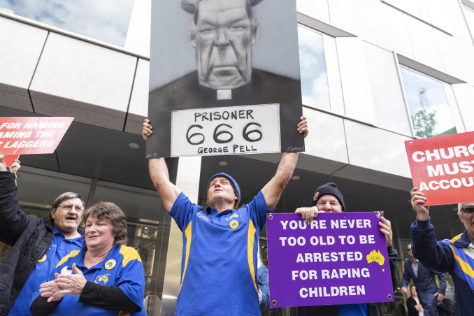 Folla con manifesti contro George Pell davanti al tribunale durante il processo per pedofilia