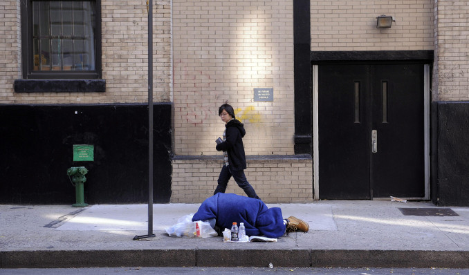 Homeless sdraiato lungo un marciapiede a New York