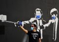 Selfie davanti a un murale di Pulp Fiction in versione emergenza coronavirus