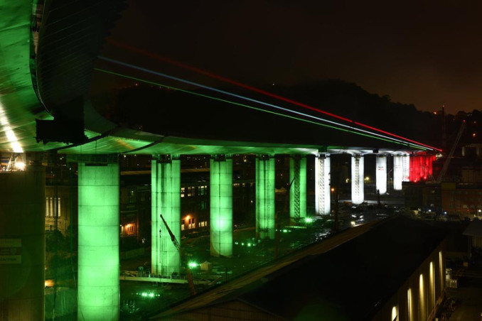 Il nuovo ponte di Genova, sorto sulle rovine del Morandi, illuminato con il tricolore