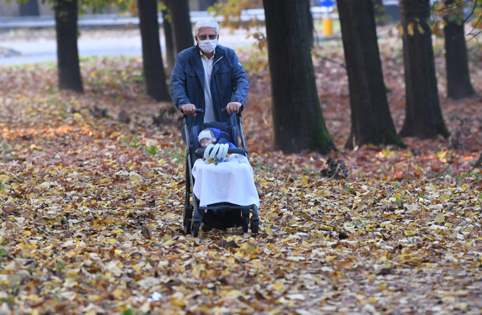 Nonno e nipote neonato passeggiano in un parco di Milano durante il lockdown