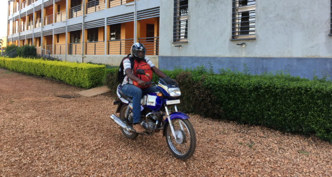 Il preside della scuola Luigi Giussani di Kampala porta i compiti in moto agli studenti durante il lockdown