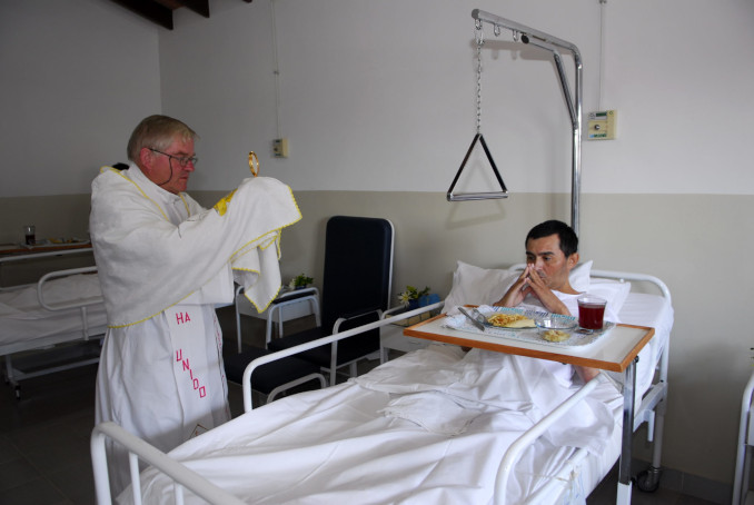 Padre Aldo Trento visita con il Santissimo un malato ricoverato nella clinica della parrocchia San Rafael ad Asuncion