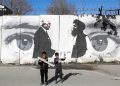 Bambini davanti a un murale che celebra gli accordi di pace di Doha tra Usa e Afghanistan