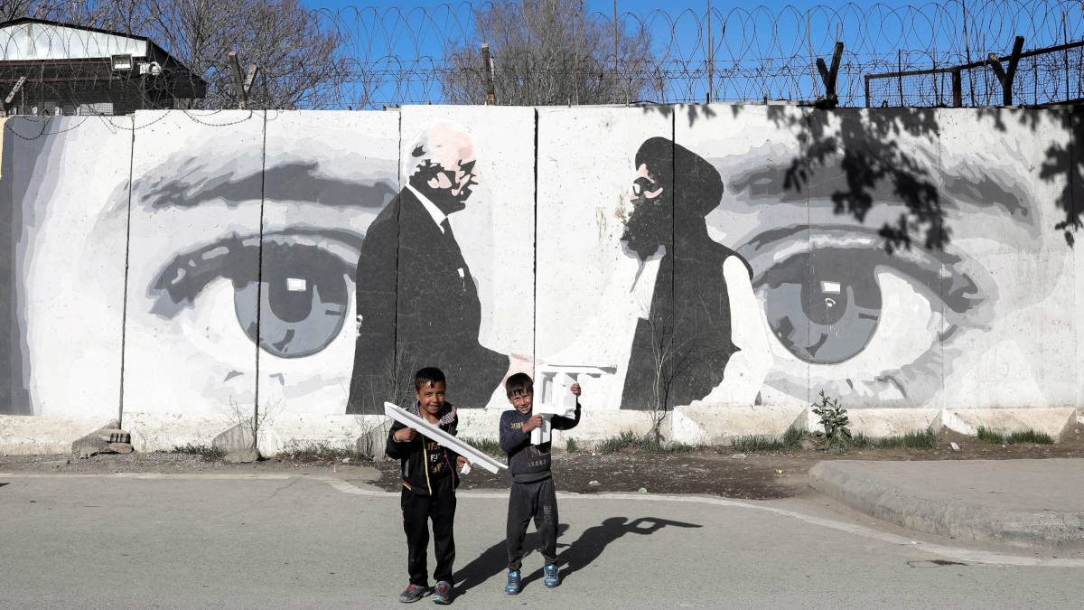 Bambini davanti a un murale che celebra gli accordi di pace di Doha tra Usa e Afghanistan