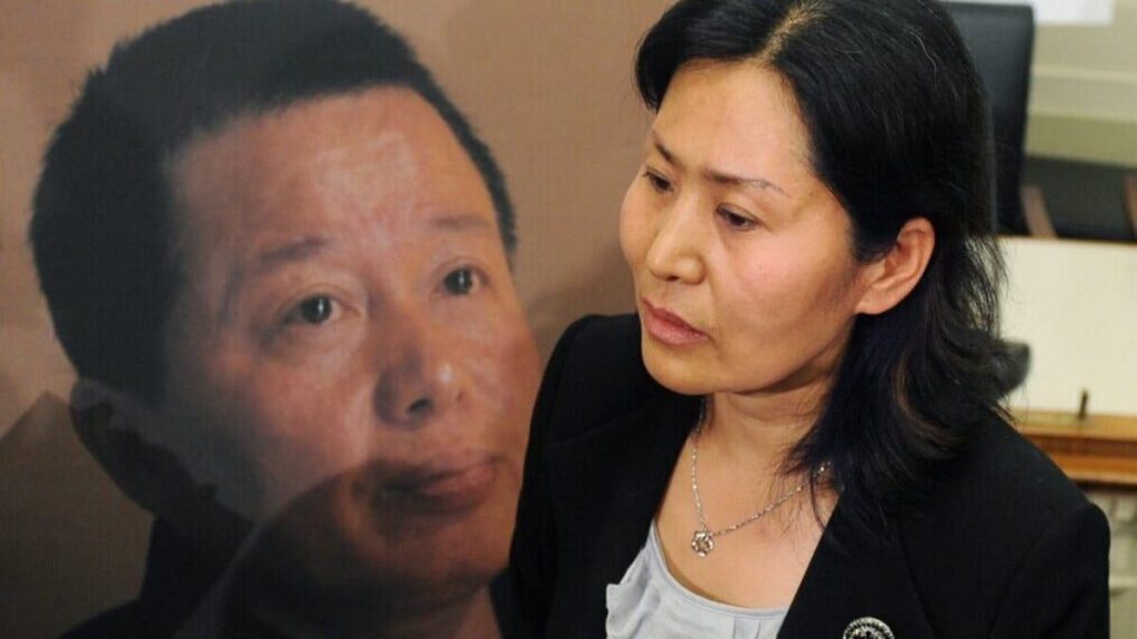 Geng He, moglie di Gao Zhisheng, davanti alla gigantografia del marito, scomparso in Cina