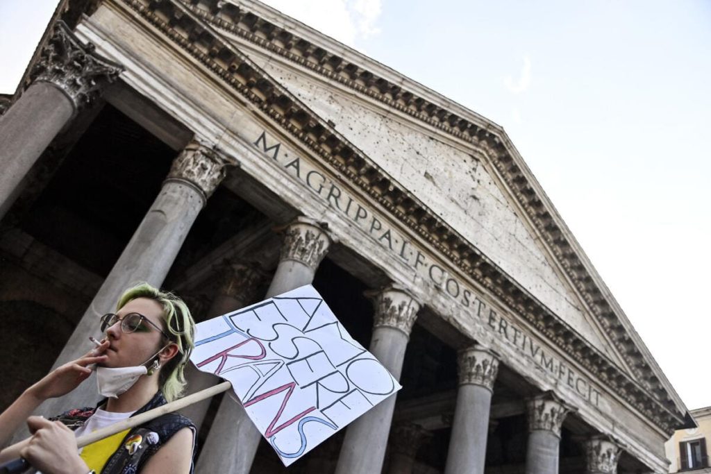 omofobia, manifestazione, ragazzo con cartello arcobaleno