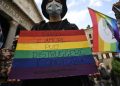 omofobia, manifestazione, ragazzo con cartello arcobaleno