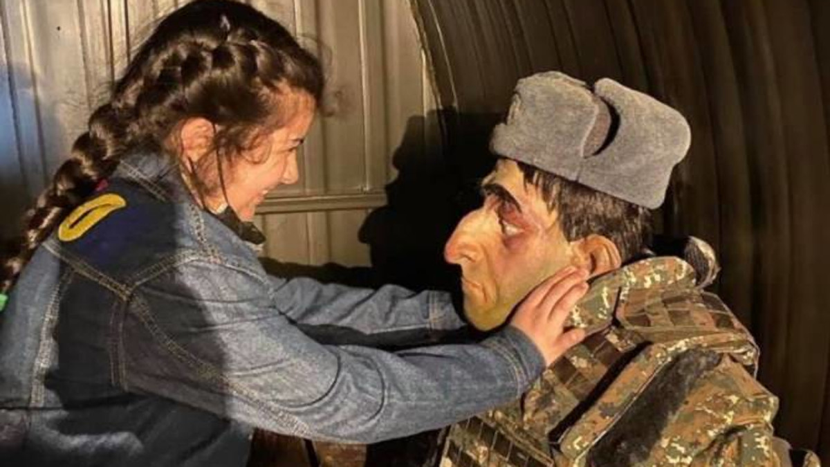 Bambina gioca con manichino di militare armeno nel "Parco dei trofei" della guerra nel Nagorno-Karabakh a Baku, Azerbaigian