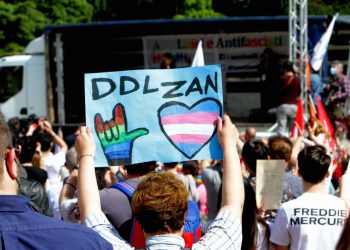 Manifestazione a Milano, un uomo alza un cartello pro ddl Zan