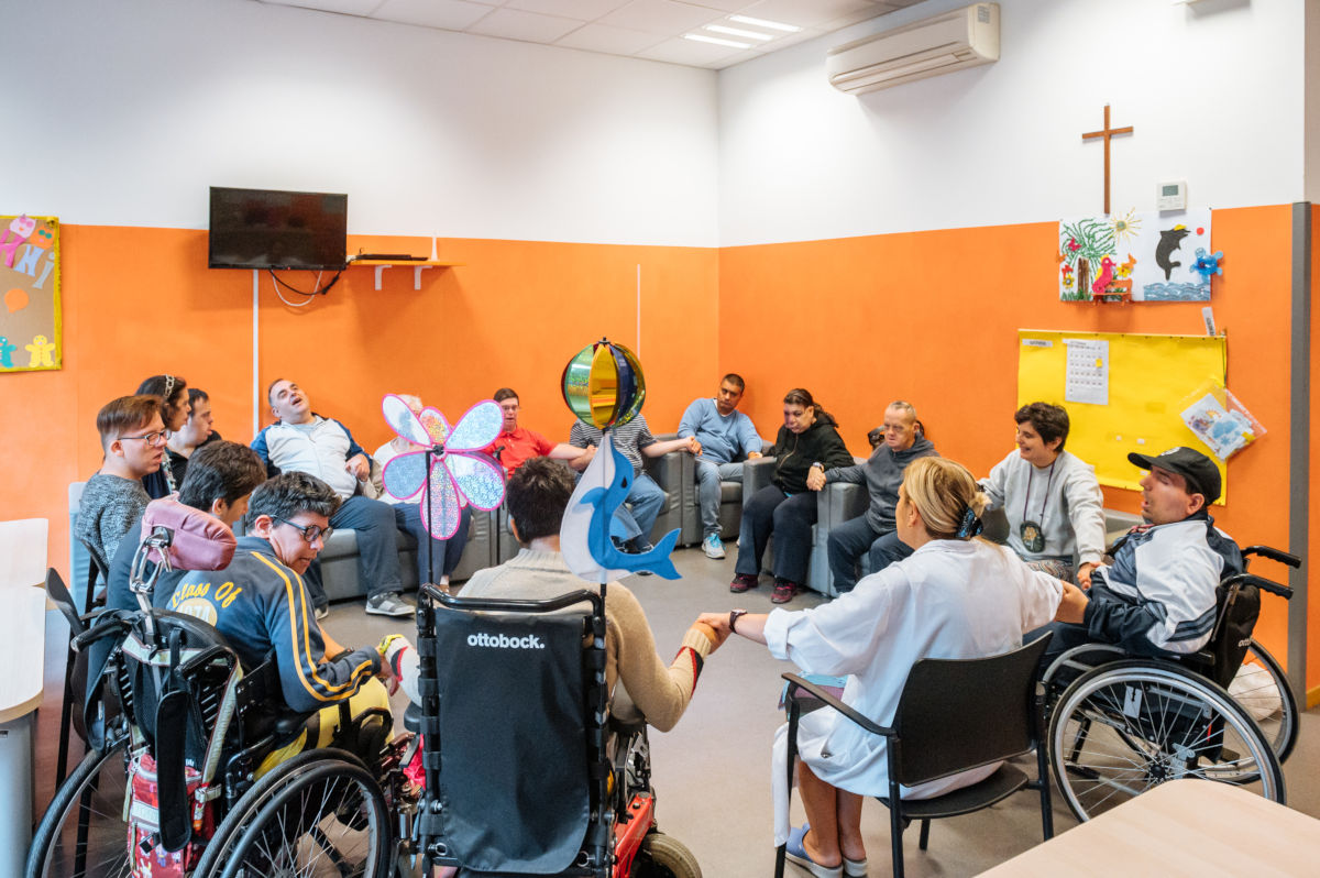Attività di gruppo con i disabili in un locale della Fondazione Sacra Famiglia