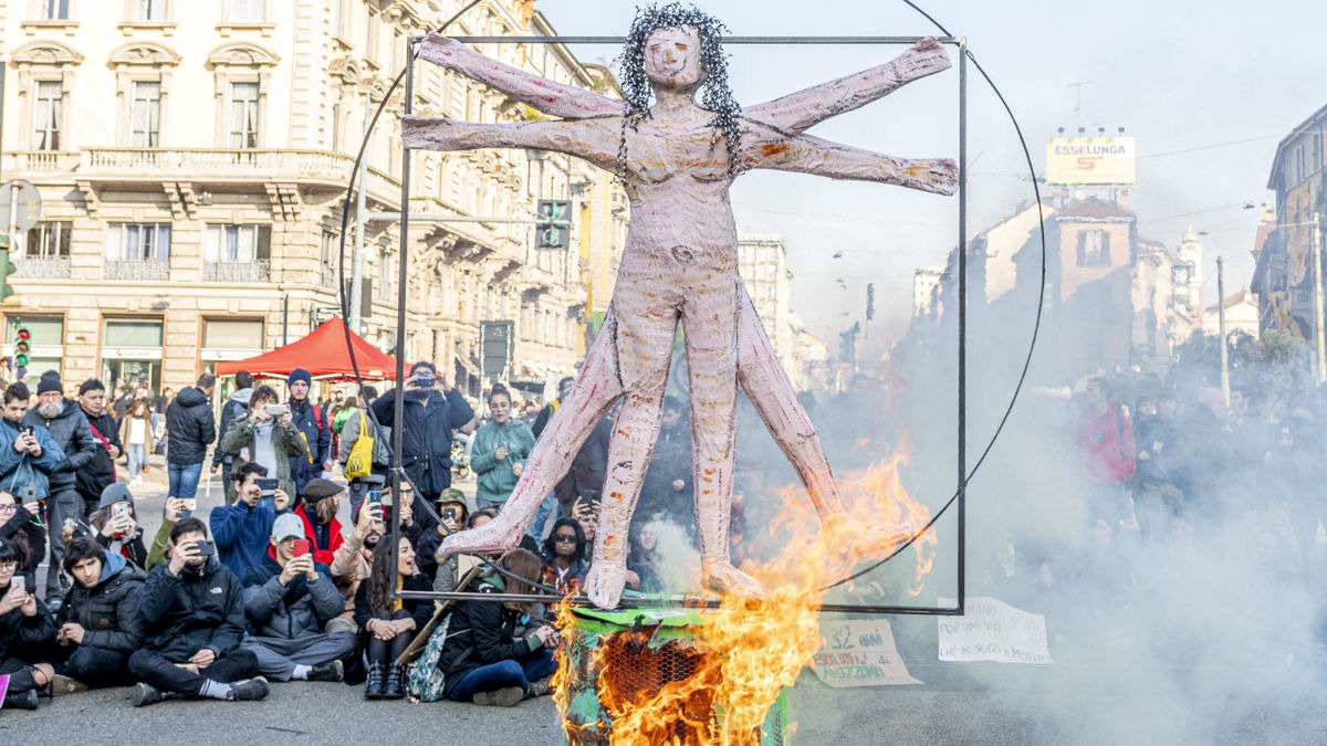 Pupazzo di uomo vitruviano in fiamme durante una Fridays for Future
