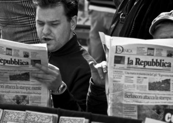 Due uomini sfogliano il quotidiano La Repubblica