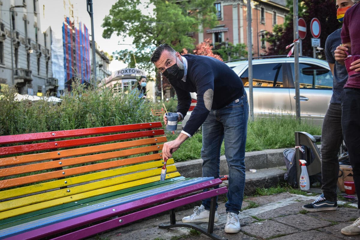 Alessandro Zan dipinge panchina arcobaleno durante una manifestazione per diritti lgbt