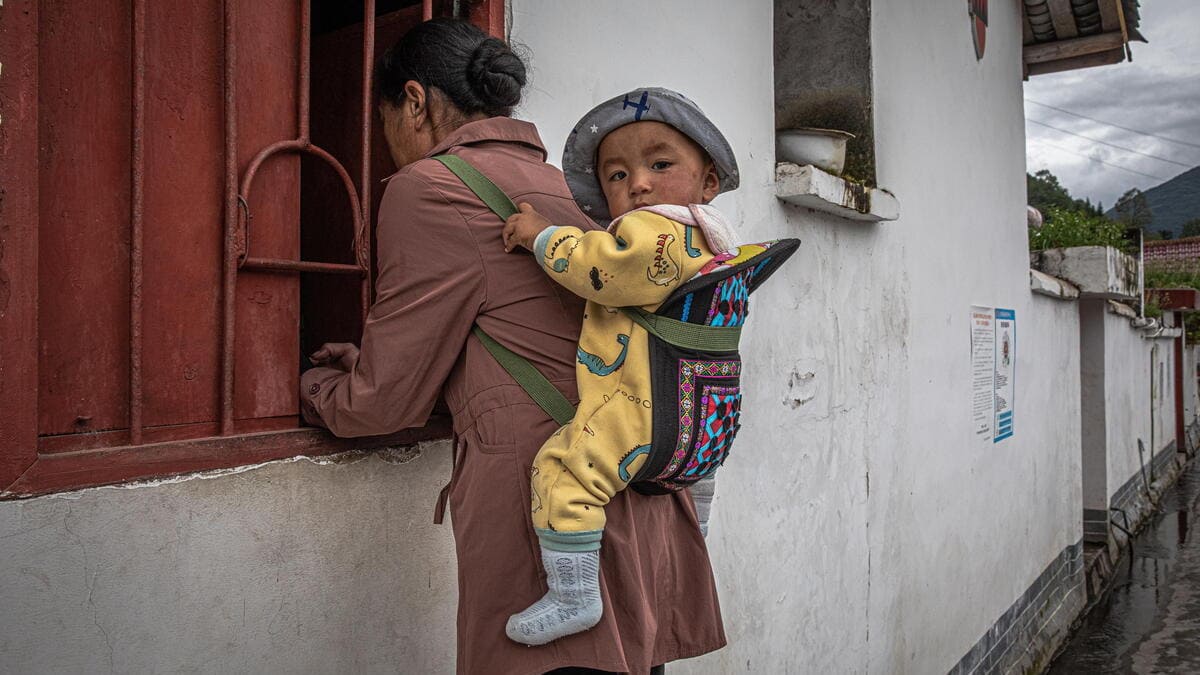 Una donna con il suo bambino in una provincia povera del Sichuan, in Cina