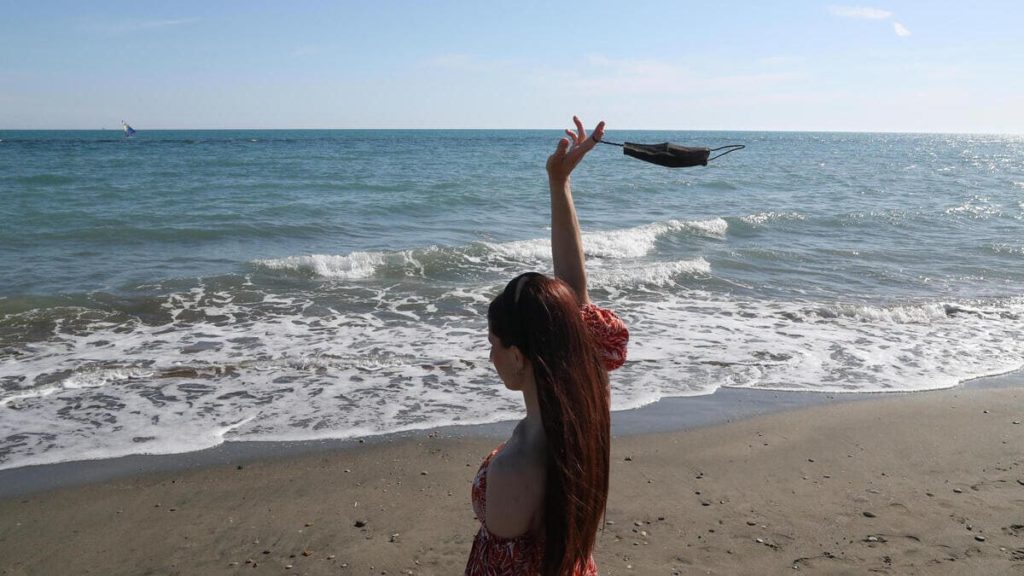 Una donna a Ostia toglie la mascherina