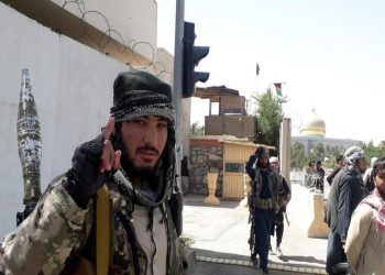 Un miliziano dei talebani esulta per aver preso il controllo dell'Afghanistan a dispetto degli Stati Uniti