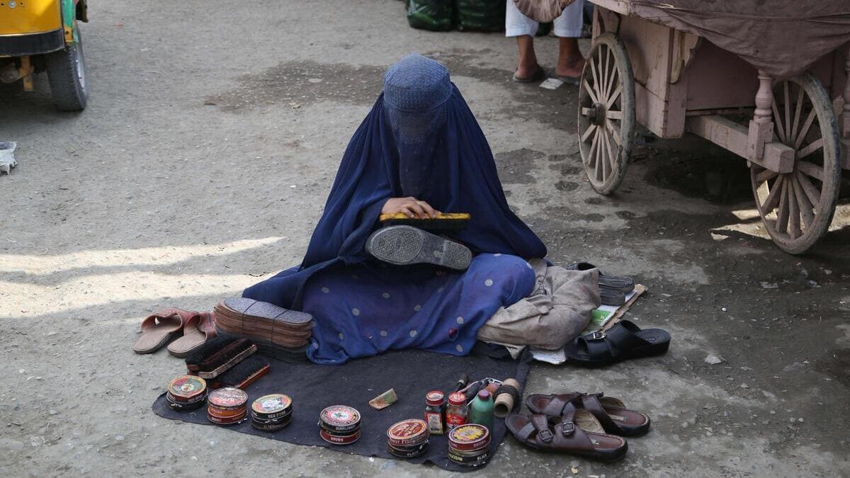 Una donna col burqa si guadagna da vivere in Afghanistan