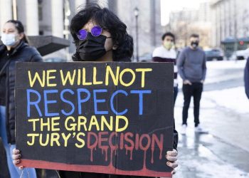 Una donna con un cartello di protesta durante una manifestazione BLM