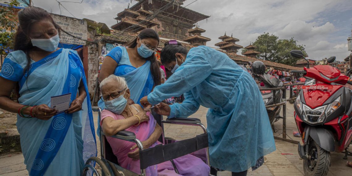 Vaccinazione anti Covid-19 somministrata a una anziana in Nepal