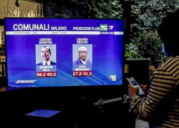 Un televisore con i primi risultati del voto a Milano nella sede del comitato elettorale di Beppe Sala (foto Ansa)