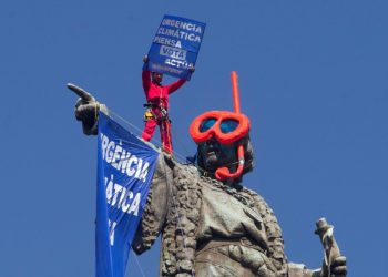 Attivista di Greenpeace protesta contro il cambiamento climatico sulla statua di Colombo a Barcellona