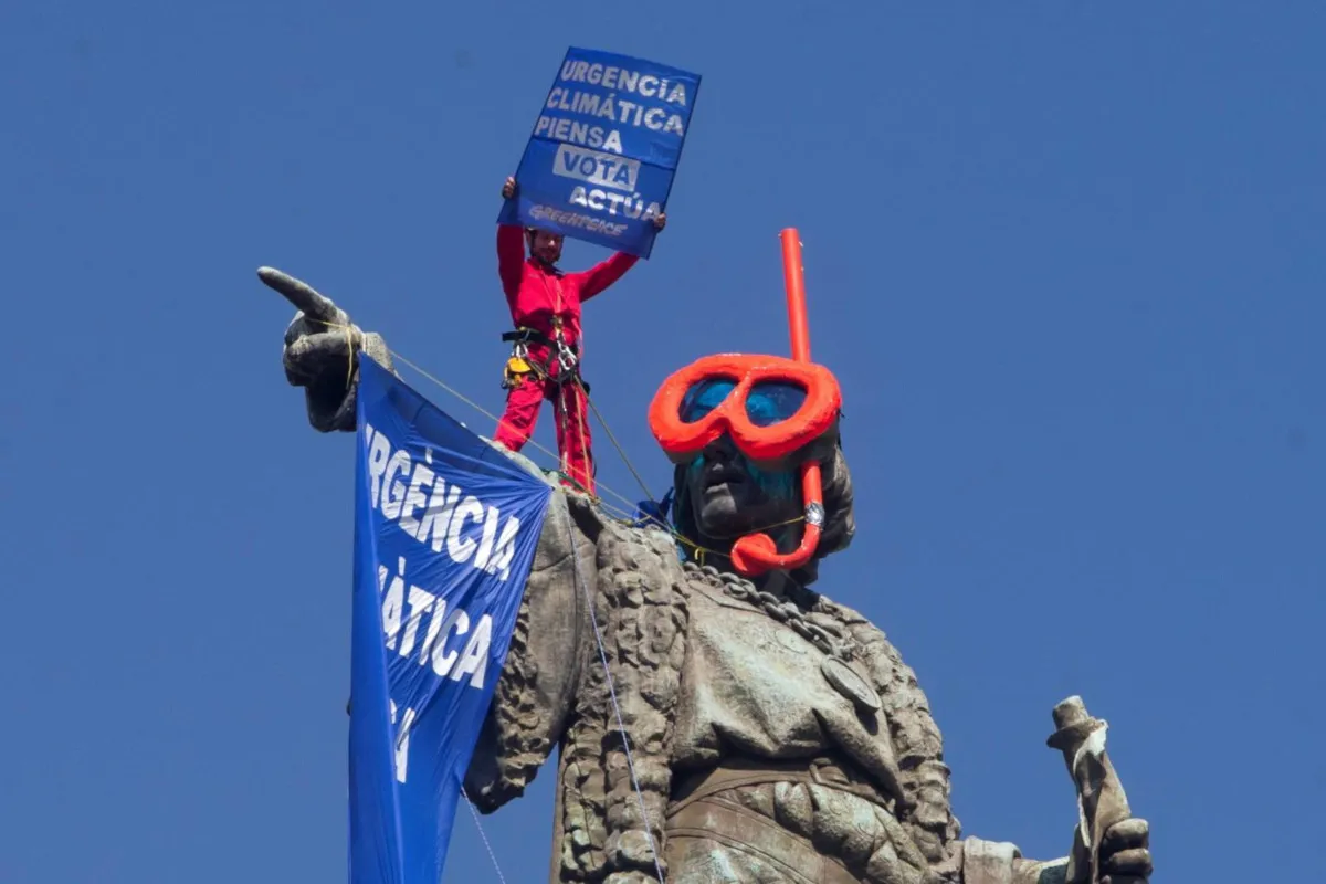 Attivista di Greenpeace protesta contro il cambiamento climatico sulla statua di Colombo a Barcellona