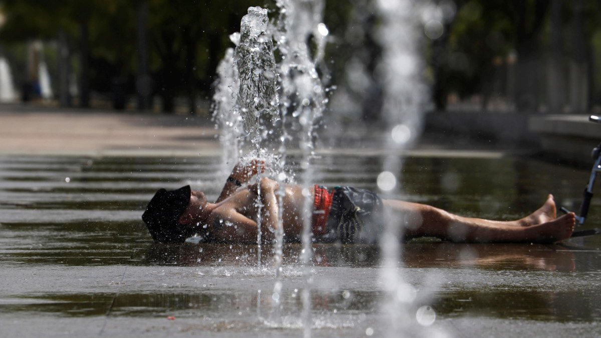 Un uomo sotto l'acqua di una fontana a Cordoba