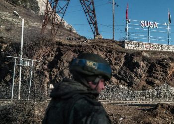 Un peacekeeper russo controlla la strada che nel Nagorno-Karabakh porta a Shushi (Susa in azero), città armena oggi controllata dall'Azerbaigian