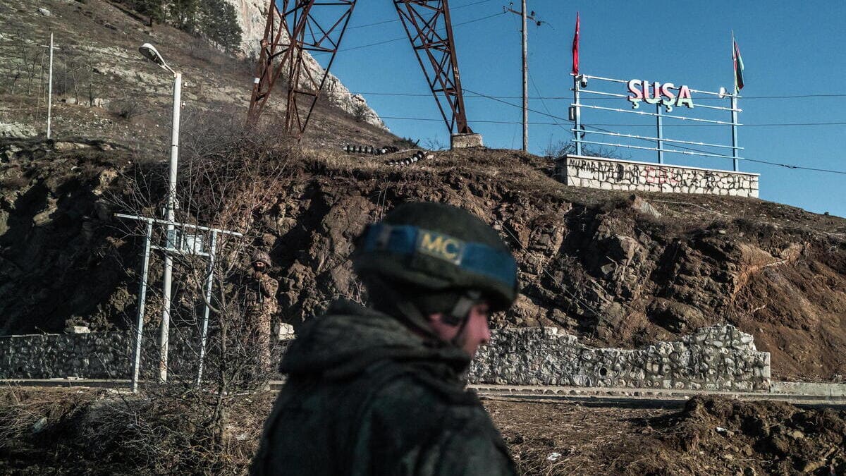 Un peacekeeper russo controlla la strada che nel Nagorno-Karabakh porta a Shushi (Susa in azero), città armena oggi controllata dall'Azerbaigian