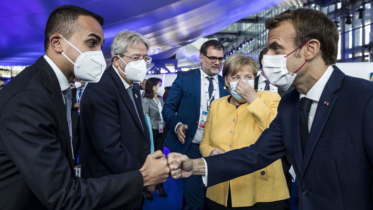 Saluto tra Luigi Di Maio ed Emmanuel Macron, dietro di loro Paolo Gentiloni e Angela Merkel