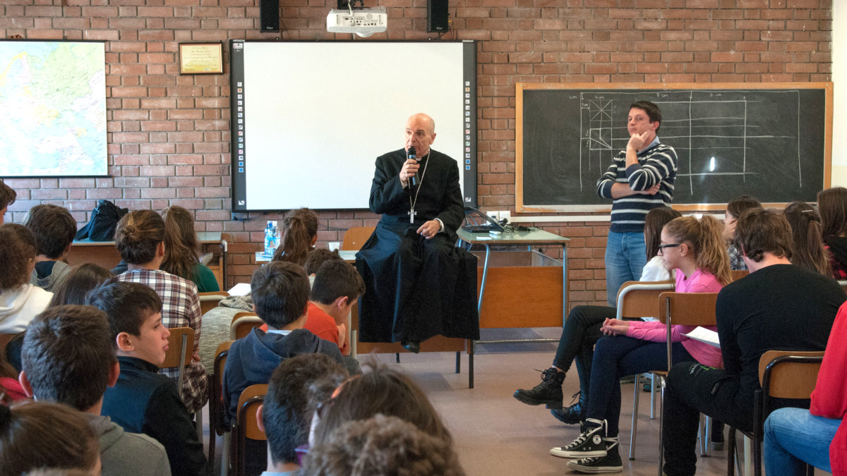 Massimo Camisasca seduto in aula tra studenti