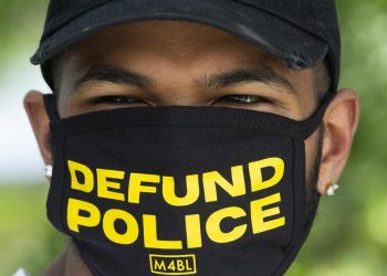 Un attivista pro Black Lives Matter promuove la campagna Defund police negli Usa