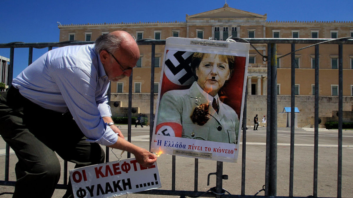 Pensionato brucia un'immagine di Angela Merkel protesta contro le riforme imposte alla Grecia dall'Europa